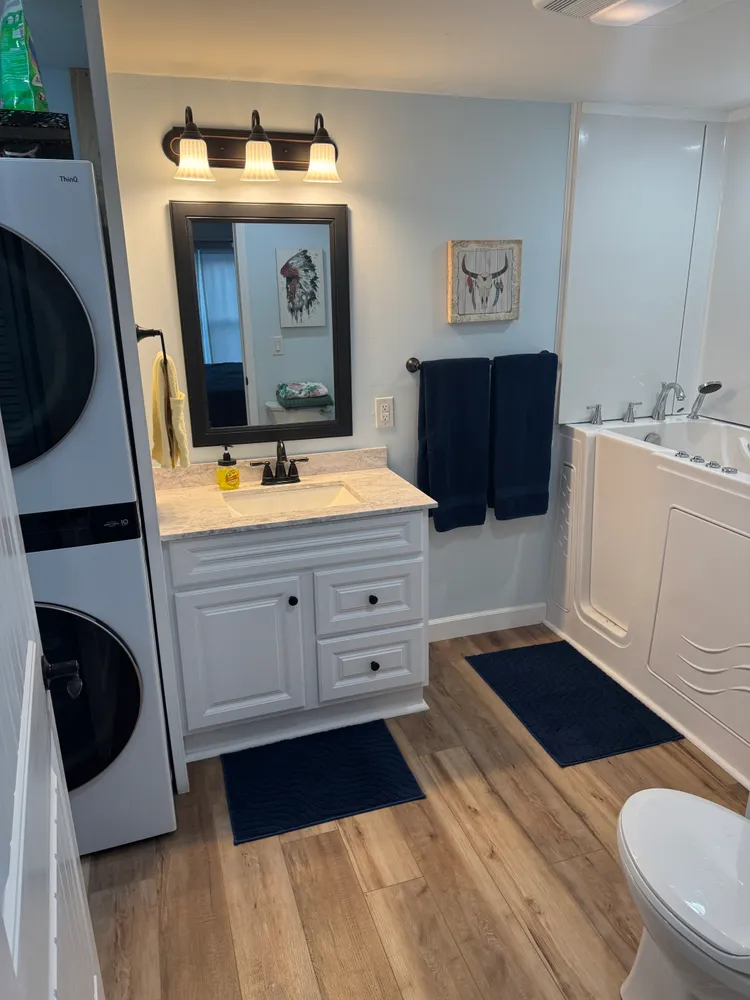 Lodge bathroom with vanity, walk-in tub and laundry machines