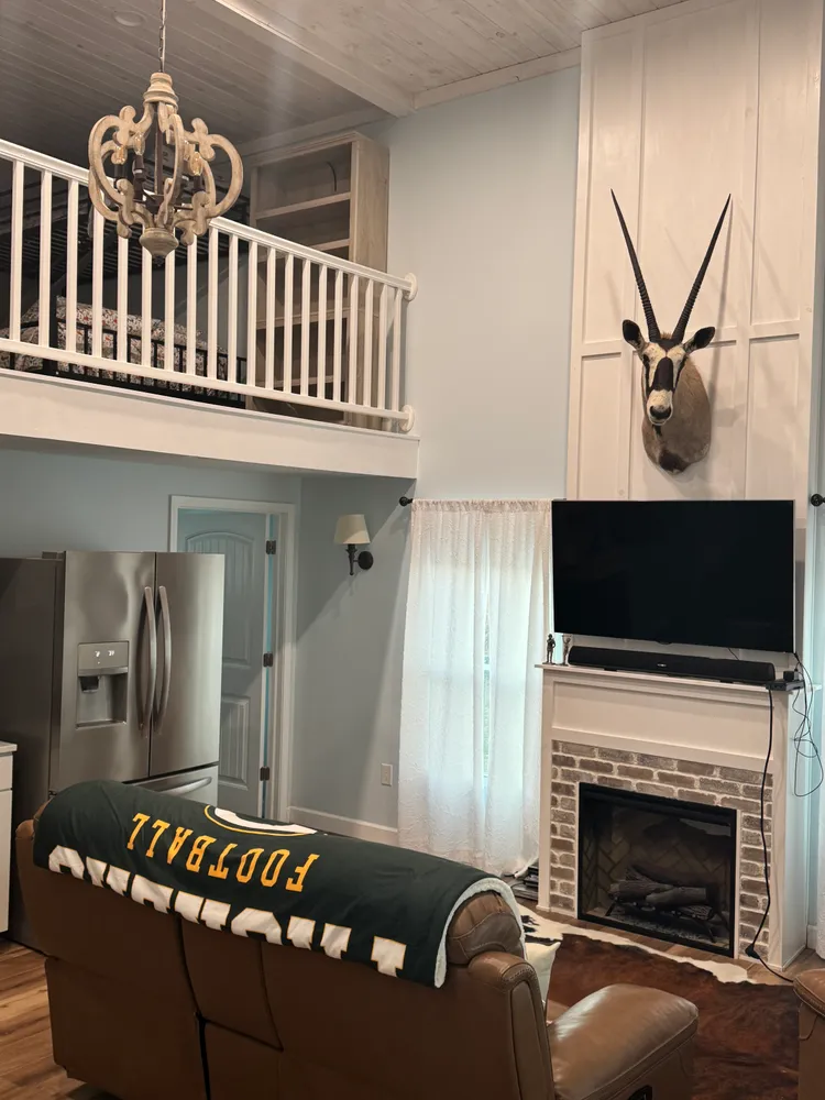 Lodge fireplace, television and upstairs loft